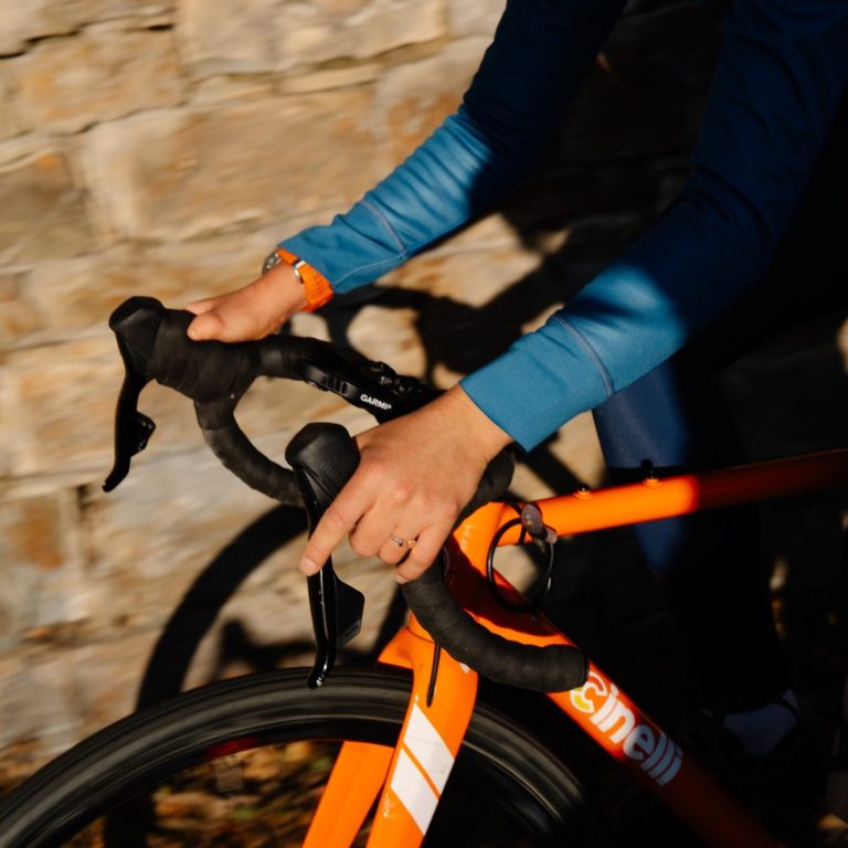 close-up of the handlebars of a roadbike with Sophie's hands